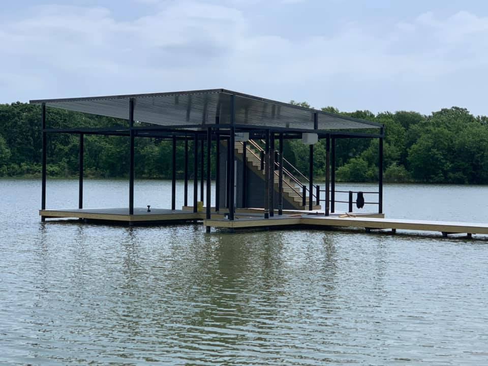 275008741_467735314883597_8072247771917184193_n Side angle view of a custom boat ramp and deck pictured with stairs on the water