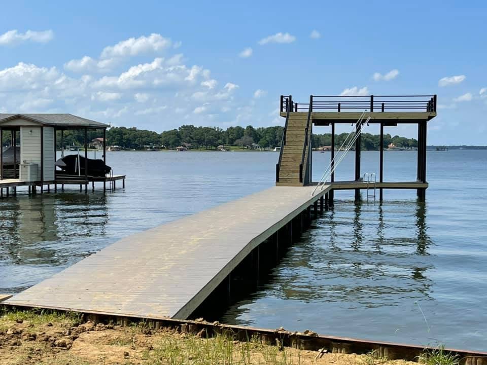 275048762_467720131551782_804959266316377115_n View further away of a deck on the water with stairs leading to a top level deck and stairs down into the water