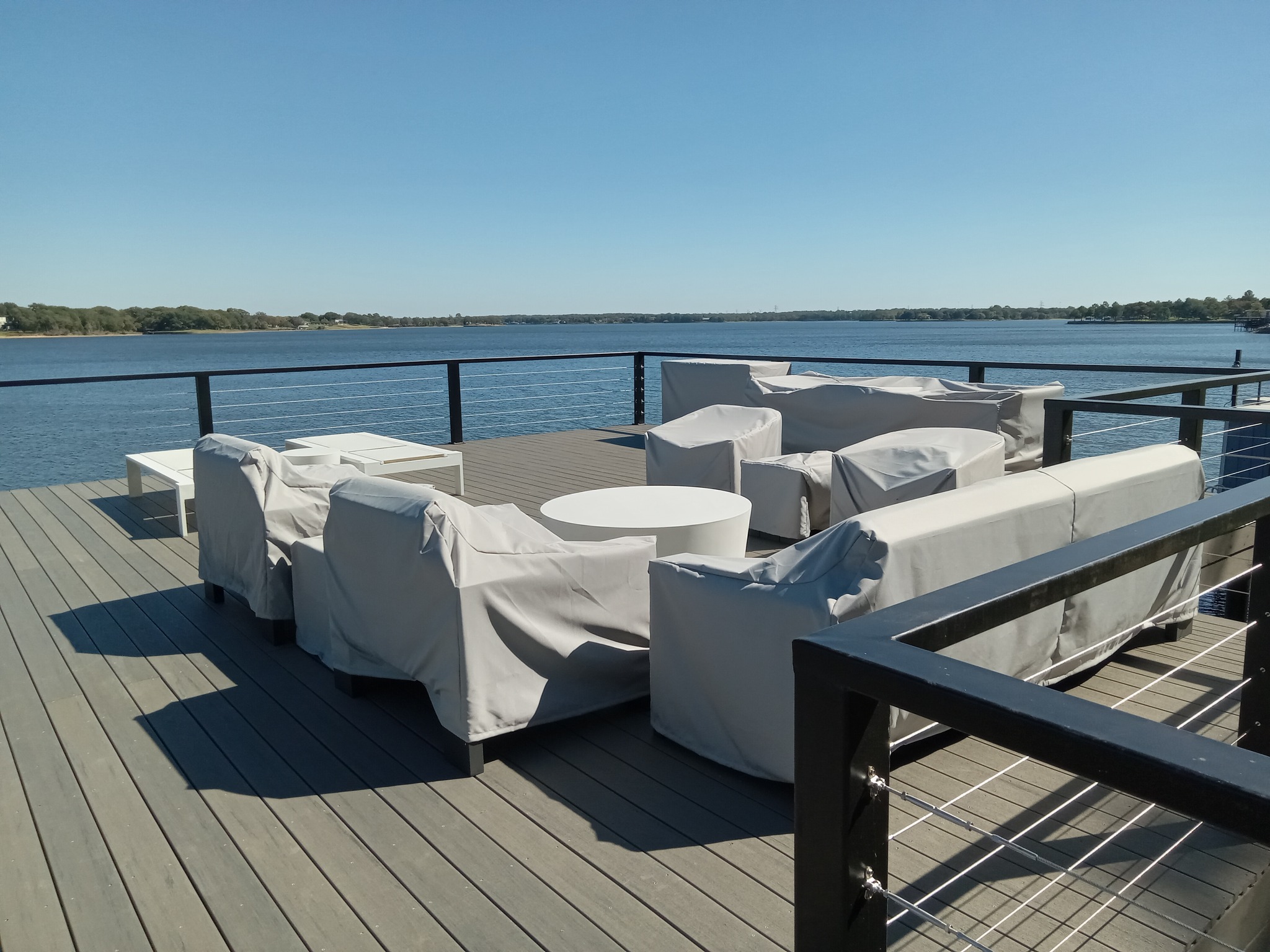 397893551_844710154330081_6649107196167213876_n A patio/deck on the water with covered furniture